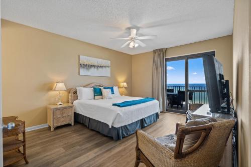 a bedroom with a bed and a television and a balcony at Phoenix 6 Unit 1213 in Orange Beach