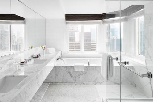 a white bathroom with a tub and a sink at The Luxury Collection Hotel Manhattan Midtown in New York
