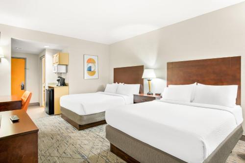 a hotel room with two beds and a desk at Holiday Inn Express & Suites - Ocean City by IHG in Ocean City