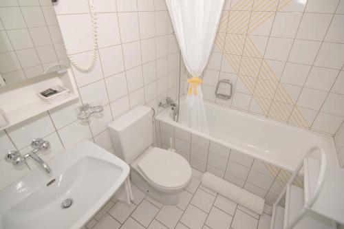 a white bathroom with a toilet and a sink at B&B Mont-Crosin in Mont-Crosin