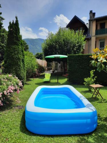 - une piscine bleue dans une cour avec un parasol dans l'établissement En bord de rivière, à Luchon