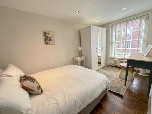 a bedroom with a white bed and a desk in it at Bloomsbury Residences in London