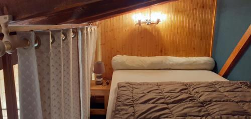 une chambre avec un lit et un mur en bois dans l'établissement Confortable Chalet Mitoyen, à Bolquère-Pyrénées 2000