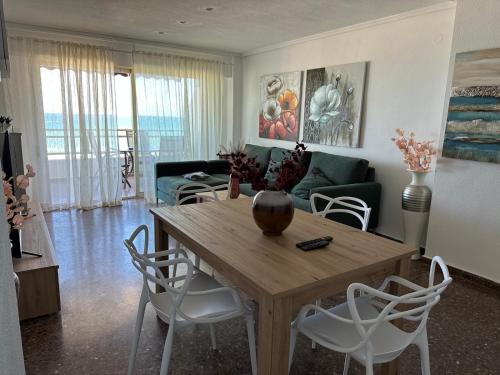 a living room with a wooden table and chairs at Euromar Playa Cullera frente al mar con garaje in Cullera