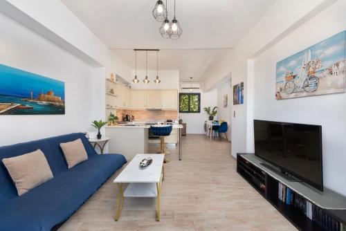 a living room with a blue couch and a tv at Antonia's Apartments in Archangelos