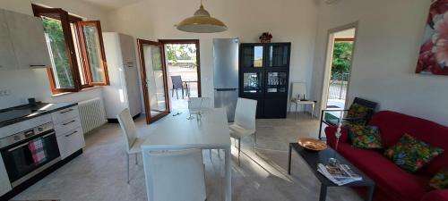 a living room with a white table and a red couch at Sweet Home Offida in San Giovanni in Strada