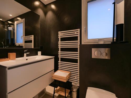 une salle de bain avec un lavabo et des toilettes et une fenêtre dans l'établissement Villa Pinède proche plage et Saint Tropez, à Saint-Tropez