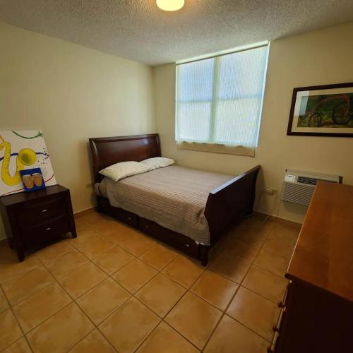a bedroom with a bed and a window at Puerto Azul Family Getaway Pool Beach 5 min in Boqueron