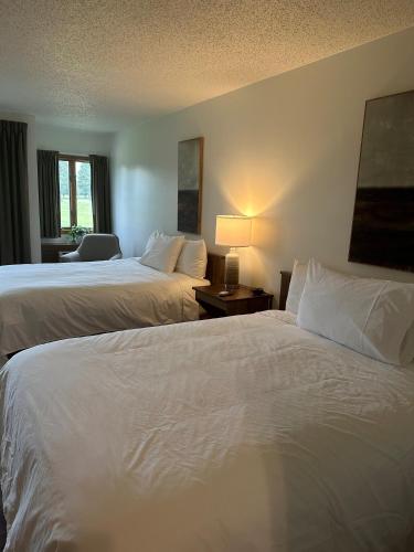 a hotel room with two beds and a table with a lamp at Lakeview Hills Golf & Resort in Lexington