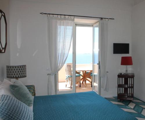 a bedroom with a bed and a sliding glass door at Limoni in Praiano
