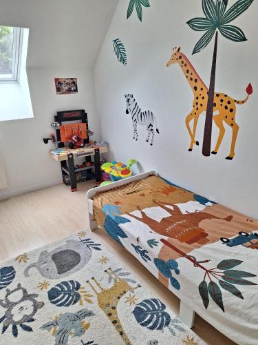 - une chambre dotée d'un lit avec une girafe sur le mur dans l'établissement Villa Foyer, à Bretteville-sur-Odon