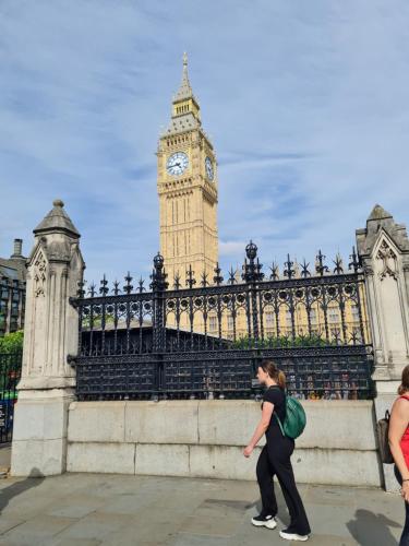 a woman walking in front of the big ben clock tower at Flourish House in Kent