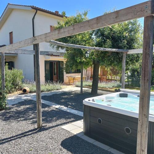 a hot tub in a yard next to a house at Macchie Basse Guest House - Agriturismo in Pescia Fiorentina