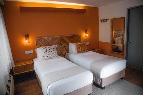 a hotel room with two beds and a mirror at qema Lima in Lima