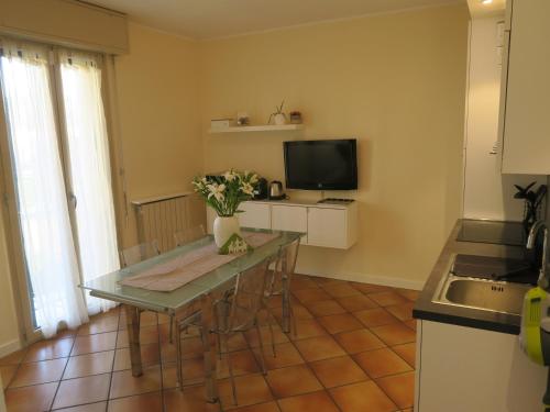 a kitchen with a table with chairs and a television at A Nest 4 Family in Erba