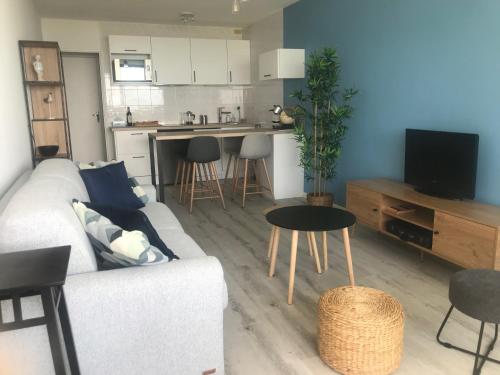 un salon avec un canapé et une table et une cuisine dans l'établissement LACANAU Océan, à Lacanau
