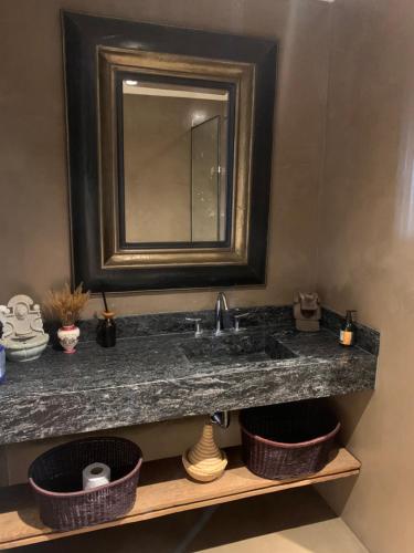 un bagno con lavandino con specchio e cestini di Casa del sol a Villa Allende