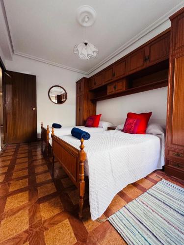 a bedroom with a bed with red and blue pillows at Apartamento centro de Nájera in Nájera