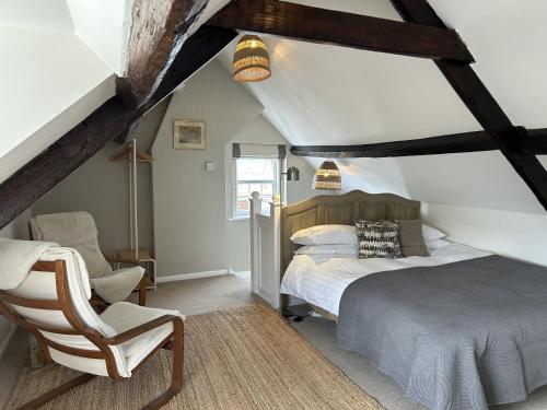 a bedroom with a bed and a chair at Bridport Town Centre Flat in Bridport