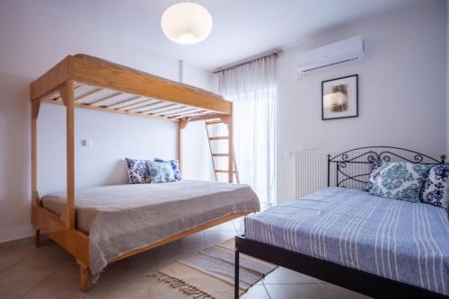 a bedroom with two bunk beds and a ladder at THREE GRACES filikon in Zakynthos Town
