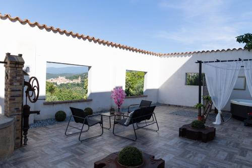 d'une terrasse avec des chaises, une table et une baignoire. dans l'établissement Moulin du désir, à Montauroux