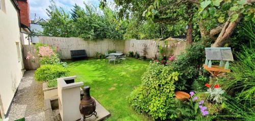 a small garden with a fence and a table and chairs at Vale View Cottages -The Coach House, Great location in Prestatyn! in Prestatyn