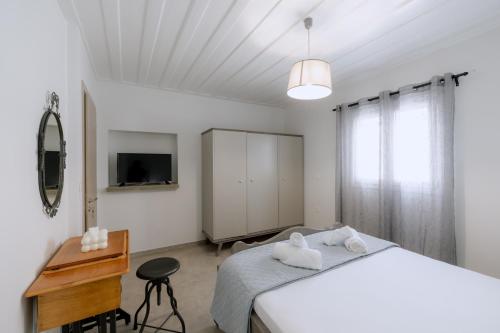 a bedroom with a bed and a desk and a television at MariThea's Guesthouse in Nafplio