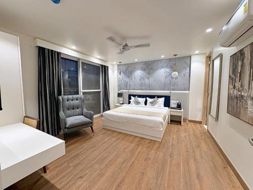 a bedroom with a white bed and a chair at The Orion Elite - Green Park in New Delhi