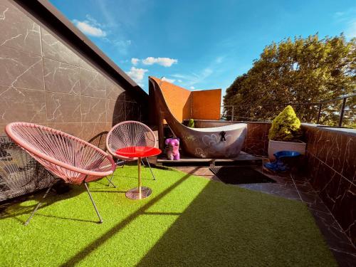 a patio with two chairs and a tub on the grass at Very Bad Hootel in Kaunas