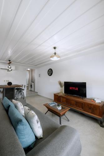 a living room with a couch and a flat screen tv at MariThea's Guesthouse in Nafplio
