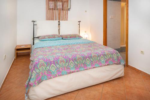a bedroom with a large bed with a colorful comforter at Jasmina-Room in Jurandvor