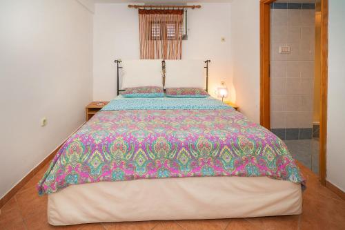 a bedroom with a large bed with a colorful comforter at Jasmina-Room in Jurandvor