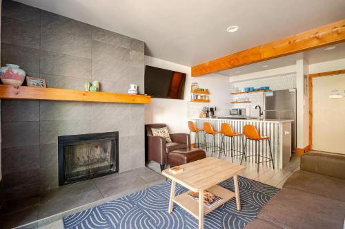 a living room with a fireplace and a table and chairs at Der Steiermark Unit 108 - Cozy King Studio Off Main St & Peak 9 Base w AC, Balcony, Shared Hot Tub & Free Parking - No Fireplace in Breckenridge
