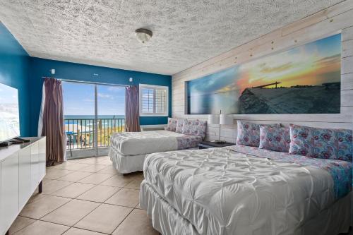 a bedroom with a bed and a couch and a window at Oceanfront Inn, Private Balcony, 2 Full Beds #16 in Fort Pierce