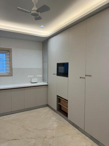 a kitchen with white walls and a ceiling at White Teak Suites 3BHK Madhapur in Hyderabad