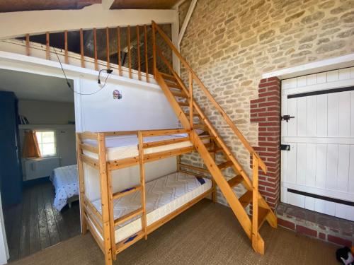 a staircase in a room with a brick wall at Gite du point du jour - Prêt de velos in Luc-sur-Mer