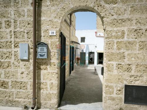 an archway in a stone building with an alley at Le Cementine Puglia On line in Morciano di Leuca