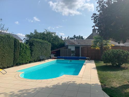 une piscine dans l'arrière-cour d'une maison dans l'établissement Maison avec piscine, à Fondettes