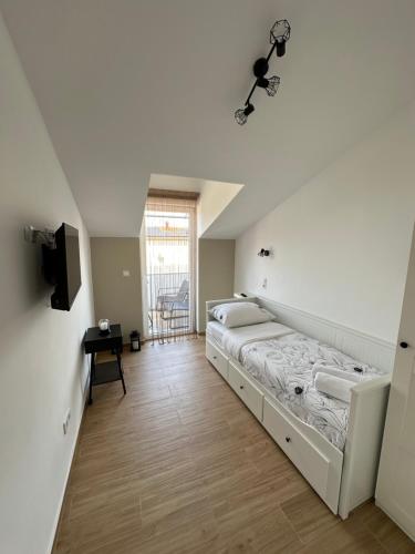 a bedroom with two beds and a tv on a wall at Apartmani M&L in Medulin