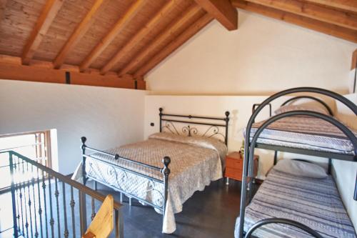 a bedroom with two beds and a balcony at Baita Michele con Terrazzo e bellissima Vista Lago x 4 Persone in Aurano