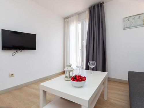 a white living room with a white table with a bowl of fruit at Apartment Mestral Atic by Interhome in Tossa de Mar