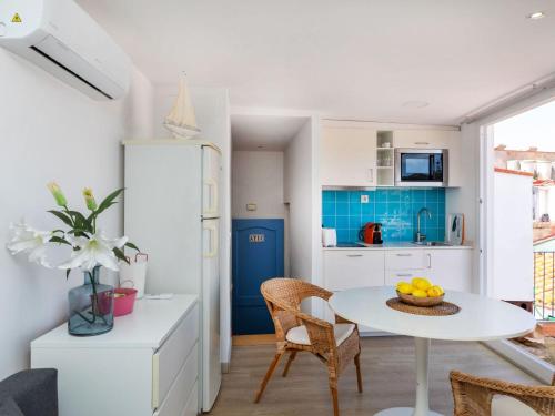 a small kitchen with a white table and chairs at Apartment Mestral Atic by Interhome in Tossa de Mar