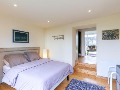 a bedroom with a white bed and a table at Holiday Home La Bellevue de Pen Ar Rhun by Interhome in Locquirec