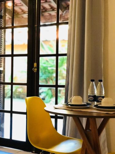 a table and two chairs and a table and a window at Canto do Una- hospedagem in Barra do Una