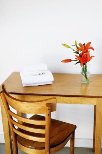 a wooden table with a vase with orange flowers in it at Art Factory Soho in Buenos Aires