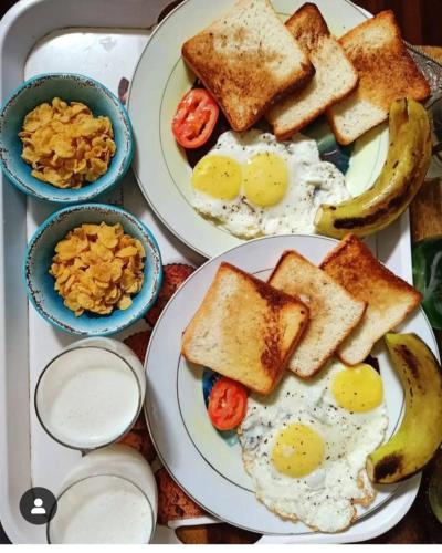 a tray of breakfast food with eggs and toast at Homestay by the Tea Garden Dibrugarh in Dibrugarh