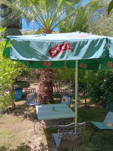 a table and chairs under a green umbrella at A-Vila in Golem