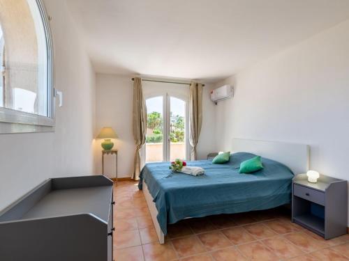 une chambre avec un lit bleu et une fenêtre dans l'établissement Villa Massenet by Interhome, à Saint-Aygulf