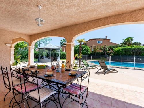 un patio avec une table et des chaises et une piscine dans l'établissement Villa Massenet by Interhome, à Saint-Aygulf