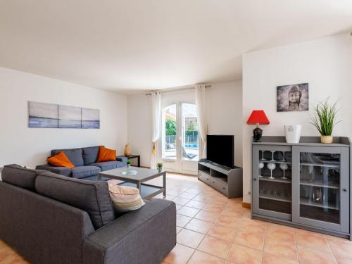 un salon avec un canapé et une télévision dans l'établissement Villa Massenet by Interhome, à Saint-Aygulf